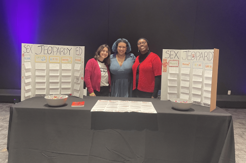 Group of graduate students hosting a table at COSI event