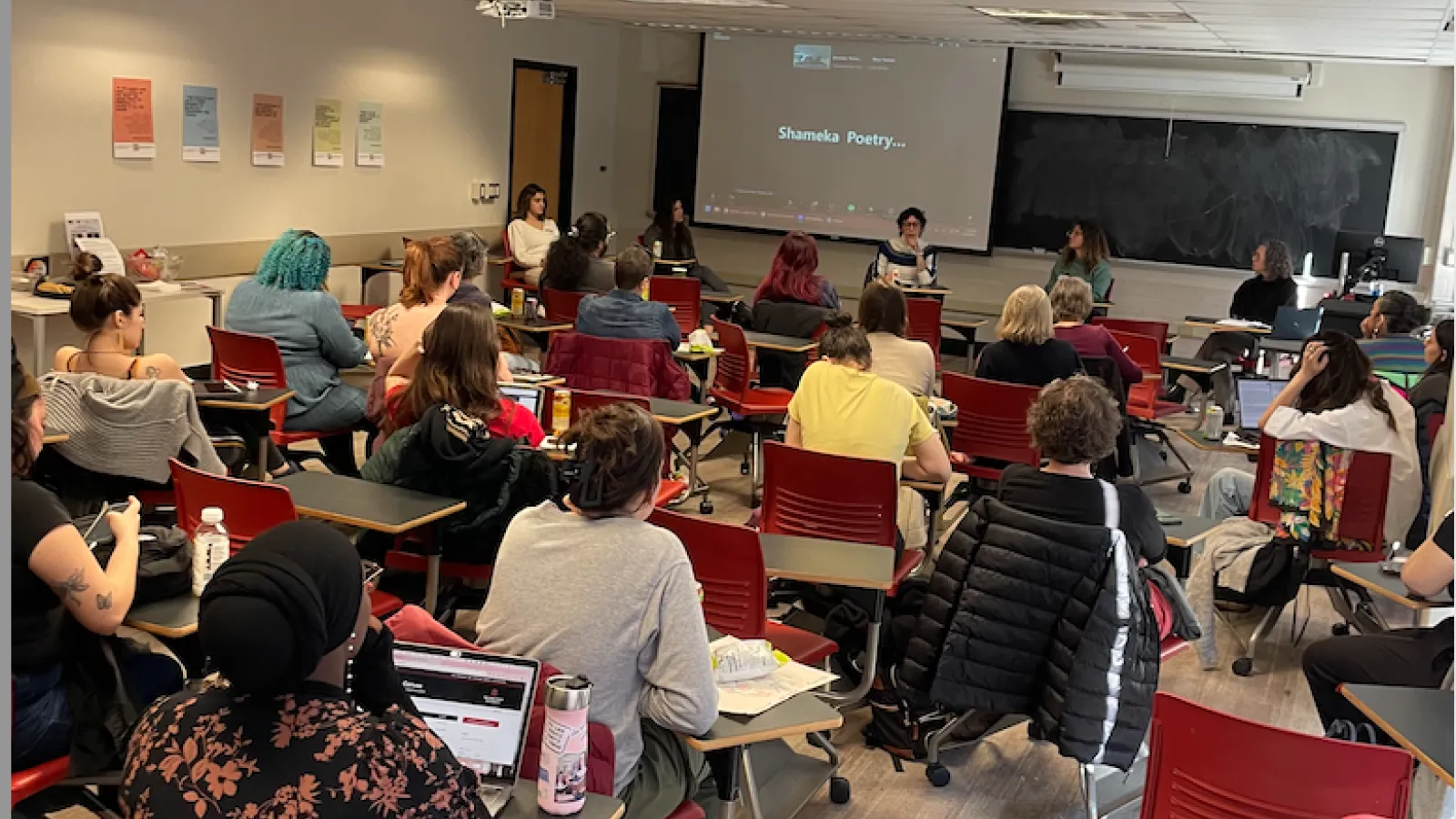 graduate students and faculty sitting at desks in a classroom