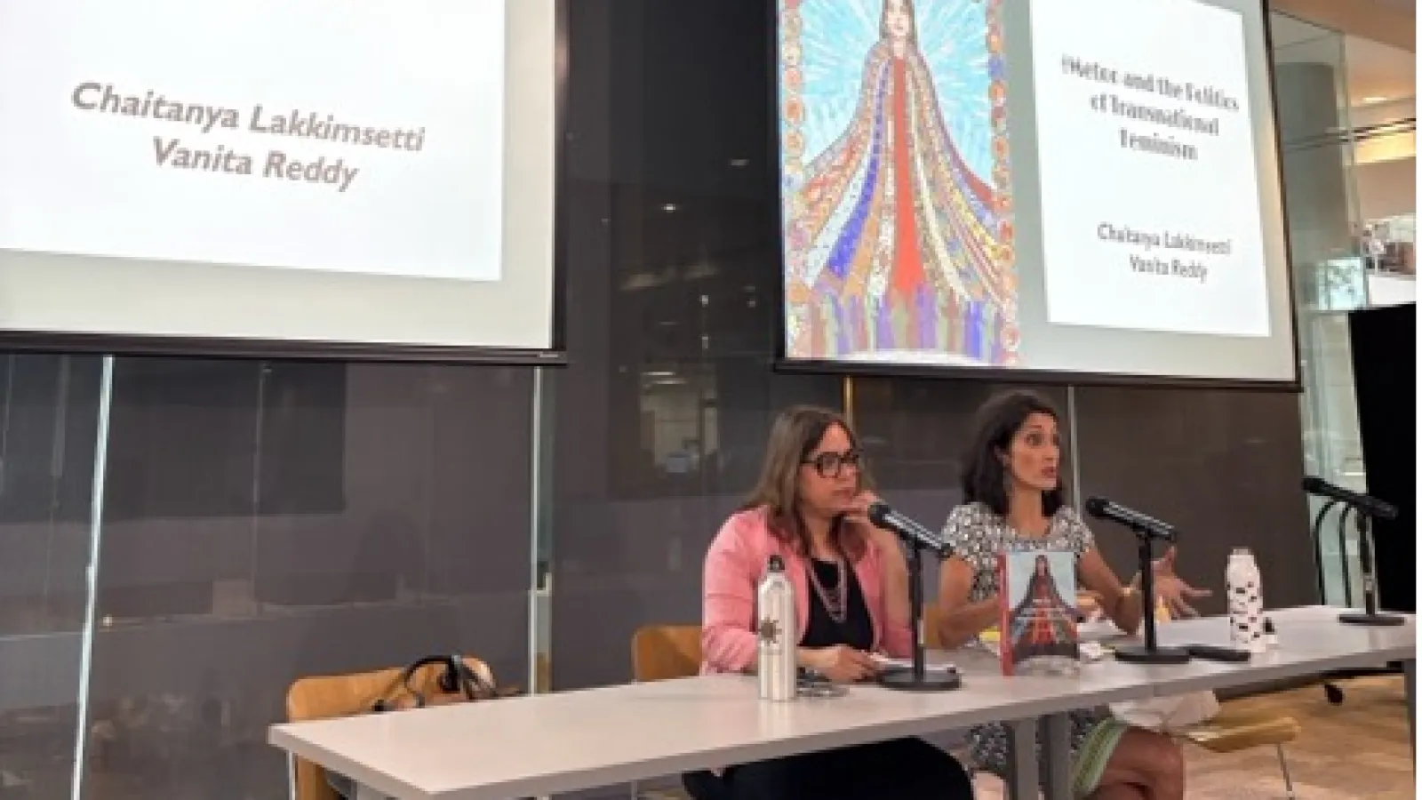Two women sitting in front of a powerpoint presentation