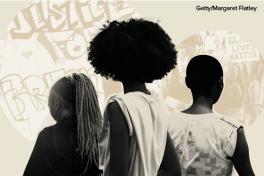 Black women and girls in front of protest art and march (image by Margaret Flatley at Getty)