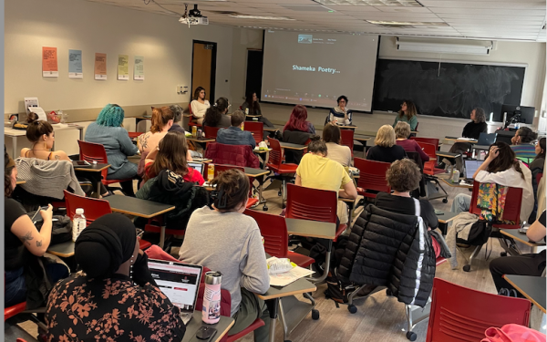 graduate students and faculty sitting at desks in a classroom