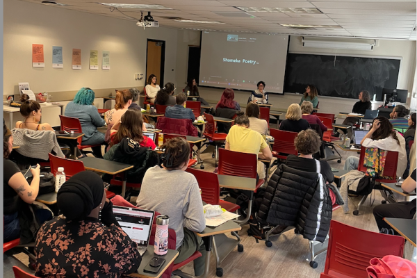 graduate students and faculty sitting at desks in a classroom