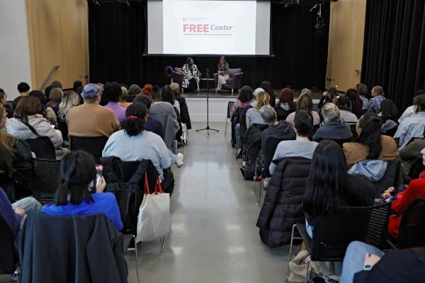Photo of Loretta Ross event, which shows Loretta Ross and Dr. Mytheli Sreenivas on stage, as well as guests in the audience.