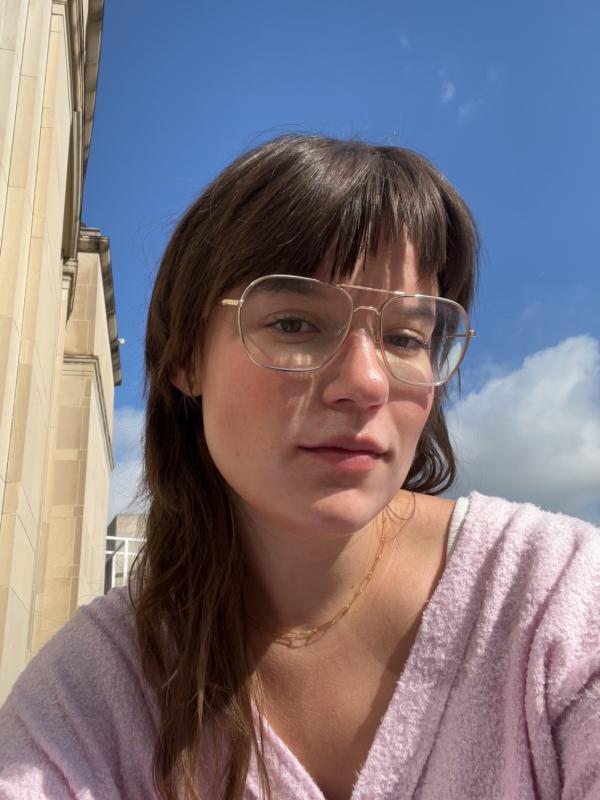Photo of Kate in a pink sweater, blue sky in background