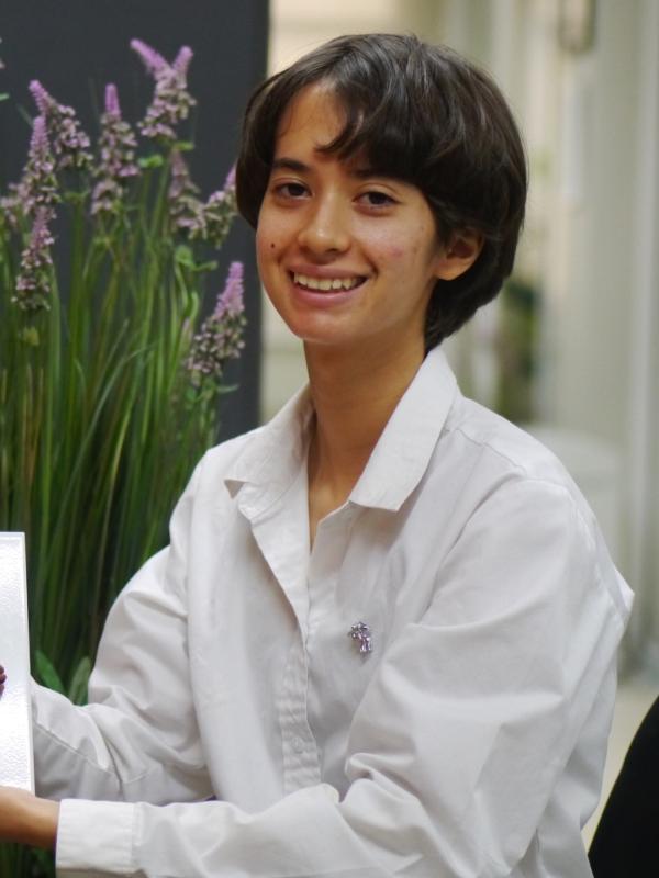 Photo of Amika in a white shirt, smiling.
